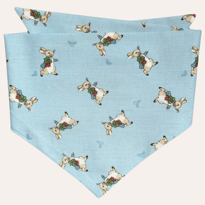 Blue pet bandana featuring Peter Rabbit with a bunch of carrots